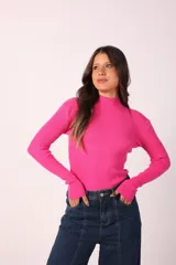 Polera fucsia de tejido de punto acanalado, con cuello alto y mangas largas.