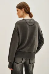 Buzo de cuello redondo y manga larga, confeccionado en algodón y viscosa con efecto lavado. Presenta un estampado frontal con tipografía en tonos degradados de violeta a rojo.