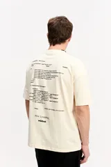 Remera boxy de color beige, de manga corta y cuello redondo, con estampa en la espalda inspirada en código de programación y estética digital.