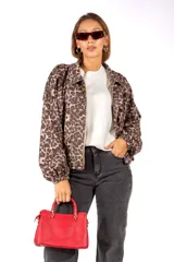 Campera de corte holgado con estampado animal print de leopardo, cuello camisero, cierre frontal y mangas largas con puños elásticos.