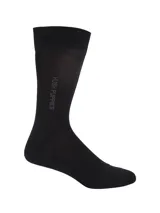 Media formal de caña media color negro, con el logo de la marca Hush Puppies estampado verticalmente en el lateral.