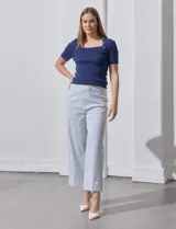 Pantalón wide leg con estampado de rayas verticales celestes y blancas, pretina con botón, bolsillos simulados en la parte delantera y ruedo con dobladillo.