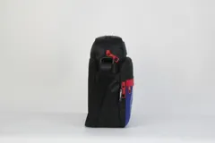 Morral cruzado de nylon negro, con detalles en rojo y azul. Presenta el logo de los Detroit Pistons en la parte superior y el nombre del equipo en relieve en el bolsillo frontal azul. Incluye correa regulable y parche con el logo de la NBA.