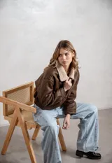 Campera de ecocuero color marrón, con forro interno de corderito sintético, cuello clásico, cierre frontal y bolsillos laterales.