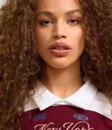 Blusa de malla de algodón con cuello de solapa y mangas largas. Tiene patrón de rayas bold y estampa delantera con lettering sportcore.