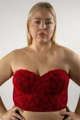 Corset corto sin tirantes de color rojo y negro, con copas armadas con aro, confeccionado en encaje con diseño floral y forrado en tul, con espalda de cintas cruzadas.