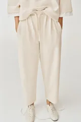 Pantalón balloon de algodón color crudo, con tiro medio, cintura elástica ajustable con cordón y bolsillos laterales.