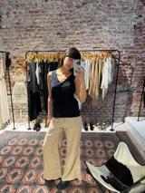 Musculosa negra con escote en V y delicados detalles de bordado broderie en la parte superior.