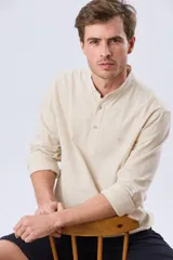 Camisa de lino y algodón color blanco, con cuello mao, manga larga y medio cierre frontal con botones.