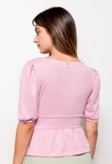 Top rosado con escote en V, mangas cortas abullonadas y elástico en la cintura.