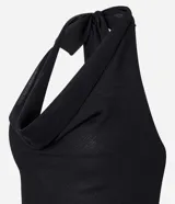 Vestido corto negro de tejido liviano, con escote halter que forma un drapeado (escote degagê) en el busto y ruedo asimétrico con volados.