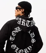 Buzo canguro negro Blue Steel de fleece con capucha, manga larga y cierre frontal. Cuenta con lettering bordado en la capucha y un diseño circular estampado en la espalda en color blanco con tipografía gótica.