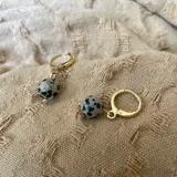 Aros colgantes dorados con piedra natural jaspe dálmata en forma de esfera.