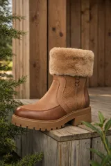 Bota de caña media confeccionada en cuero vacuno con textura combinada en tonos marrón y tostado. Presenta un cuello con forro de corderito sintético, punta redonda y suela de goma tipo track con plataforma.