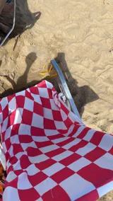 Bolso de playa convertible en toalla, con estampado de cuadros grandes en blanco y azul.