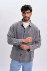 Sobrecamisa de franela color azul con patrón a cuadros, manga larga, bolsillos frontales con solapa y cierre de botones.