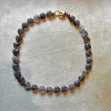 Collar de cuentas de ágata natural talladas en forma de corazón, con cierre metálico dorado.