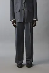 Pantalón de traje con corte flare fit, confeccionado en tejido con lana. Presenta diseño de tiro medio con pinzas frontales, bolsillos laterales y bolsillos traseros de vivo. Cierre frontal con cremallera y botón.