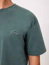 Remera negra de corte suelto y mangas cortas, con pequeño bordado a tono en el pecho.