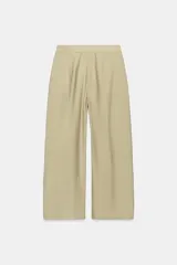 Pantalón de tiro medio color beige perteneciente a la colección ZW Collection, de corte ancho y recto, con detalle de pliegues frontales y cierre con cremallera y ganchos metálicos.