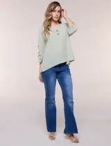 Blusa Erika de algodón con estampado de rayas en tonos azules, rosados y amarillos. Presenta cuello redondo con escote en V y botones frontales, mangas cortas decoradas con una fila de botones en los laterales y dobladillo asimétrico.