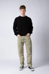 Jean de corte mom oversize, color negro lavado, con diseño de cinco bolsillos y cierre frontal con botón y cremallera.