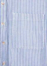 Camisa crop de manga corta con diseño de rayas celestes y blancas, cuello camisero, cierre frontal de botones y un bolsillo parche delantero.