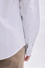 Camisa de manga larga oxford en color blanco, con cuello abotonado y bolsillo frontal en el pecho.