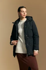 Campera acolchada de nylon en color crema, con capucha ajustable, cierre frontal con botones y cordón de ajuste en la cintura.