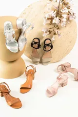 Sandalias de cuero color suela con taco cuadrado bajo y tira ajustable con hebilla en el tobillo.