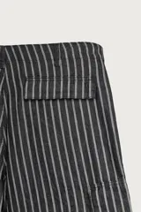 Bermuda cargo relaxed fit confeccionada en denim de mezcla de algodón y lino, con diseño de rayas verticales grises y negras. Cuenta con bolsillos laterales tipo cargo con solapa y cierre frontal con cremallera y botón.