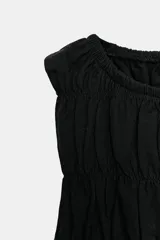 Top sin mangas de color marrón, con cuello redondo y diseño completamente fruncido con elásticos y un sutil volante en el bajo.