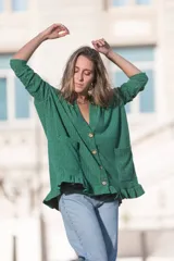 Saco verde esmeralda de tejido morley con botones de madera, corte holgado, escote en V, mangas largas y volados en el ruedo.