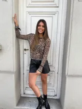 Remera de microtul con estampado animal print de leopardo, cuello alto, mangas largas con lazos ajustables en los puños.