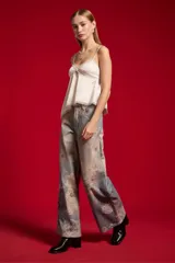 Musculosa de satén color blanco, con breteles finos regulables, escote en V decorado con detalles de encaje y diseño fluido.