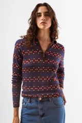 Camiseta de manga larga con cuello polo y cierre frontal parcial, confeccionada en tejido de punto con estampado geométrico en tonos azul, bordó y celeste.