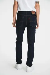 Pantalón de jean azul oscuro, de corte skinny, tiro medio y calce ajustado.