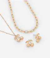 Conjunto de collar y caravanas doradas con colgantes de cerezas. Incluye un collar corto de eslabones, un collar largo de esferas y un par de caravanas con forma de cerezas.