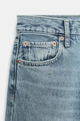 Jeans de tiro medio con corte recto y largo al tobillo. Presentan diseño de cinco bolsillos, cierre frontal con cremallera y botón, y ruedo deshilachado.