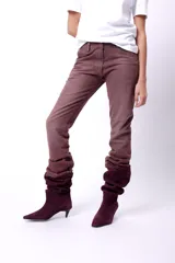 Jean de tiro medio color marrón, de corte recto y largo, con efecto arrugado en la parte inferior.