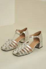 Sandalias plateadas de cuero acharolado con puntera calada, pulsera ajustable y tacón bloque.