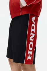 Short de ripstop negro con corte holgado, cintura elástica con cordón de ajuste y franjas laterales rojas con ribete blanco.