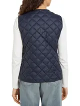 Chaleco azul marino acolchado con relleno de plumón, sin cuello y cierre a presión. Cuenta con el logo de Tommy Hilfiger bordado en el pecho.