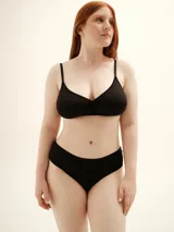 Soutien negro de copa soft sin aro, con tirantes finos ajustables y detalle de frunce central.