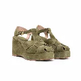 Sandalias de plataforma con taco corrido y tiras cruzadas en el empeine, confeccionadas en gamuza color verde militar. Cuentan con tira en T y pulsera ajustable al tobillo con hebilla metálica dorada.