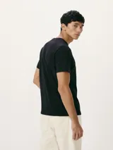 Remera de corte regular color beige con cuello redondo, mangas cortas y estampa frontal de pequeños nudos marineros en tono azul.