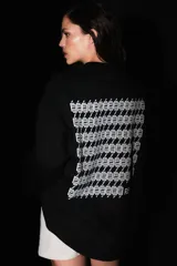 Buzo negro oversize de frisa con cuello redondo, hombros caídos y terminaciones de rib. Presenta logo bordado a tono en el frente y estampa serigrafiada a contratono en la espalda.