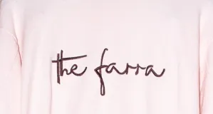 Sweater de punto color rosado con cuello redondo, mangas largas y el logo 'the farra' bordado en el frente.