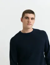 Sweater de punto inglés con escote redondo y mangas largas. Presenta cuello y puños terminados en punto canalé.