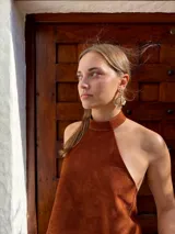 Caravanas colgantes de diseño floral con pétalos texturizados en tono dorado y detalles de pequeñas perlas en la parte superior.